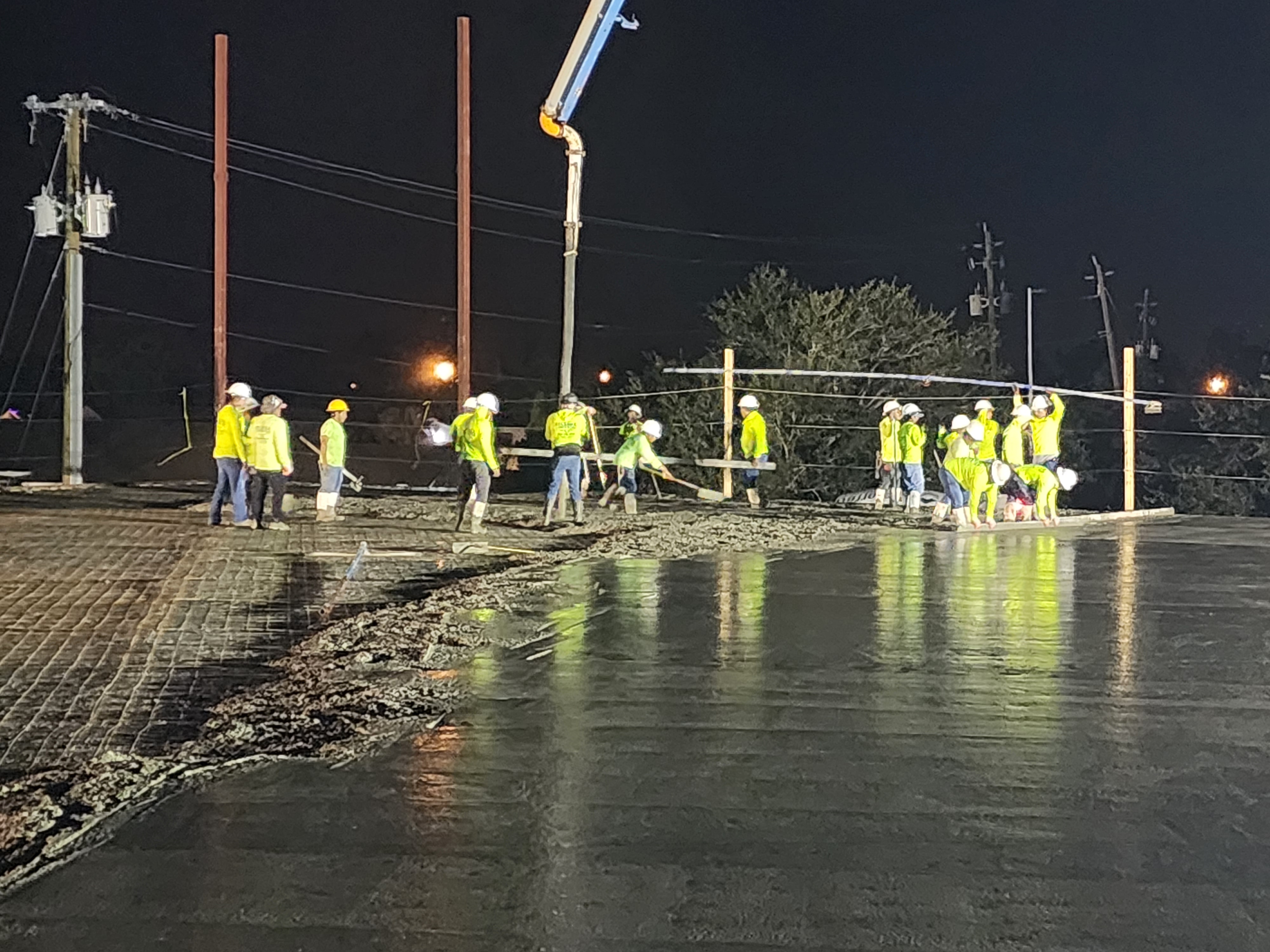 Crew finishing a concrete slab at night